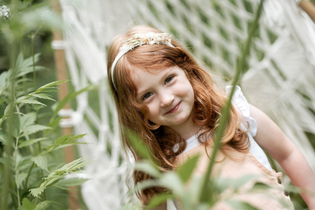 Kind bei einem Fotoshooting vor einem Natur-Set.