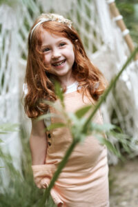 Kind lacht bei Outdoor-Shooting aus tiefstem Herzen.